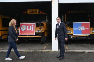 Quebec Conservative Leader Eric Duhaime and local candidate Maite Blanchette-Vezina Duhaime in front of two buses with 1995 Yes and No referendum signs, at a campaign wrap up news conference in Quebec City, Friday, Oct. 2, 2026.
