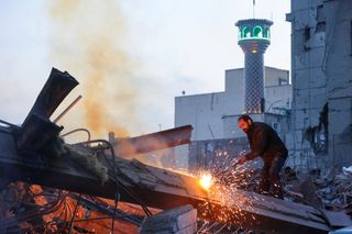 Ein Mann arbeitet in Teheran inmitten von Trümmern einer Polizeistation
