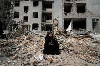Eine Frau sitzt vor Trümmern in Teheran (Symbolbild)