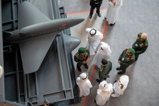 Besucher inspizieren eine Drohne vom Typ Falcon Shadow 25 auf der Waffenmesse IDEX in Abu Dhabi, 2023