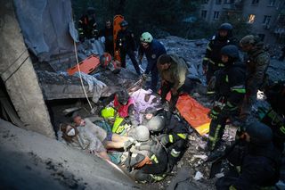 Rettungskräfte bergen eine Familie aus den Trümmern eines Wohnhauses.