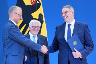 Bundeskanzler Friedrich Merz (l.) gratuliert Alexander Schweitzer (r.) zur Ministerernennung durch Bundespräsident Frank-Walter Steinmeier (Mitte).
