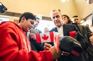 Prime Minister Mark Carney attends a national unity rally in Red Deer, and signs an autograph on Friday Oct. 16, 2026.THE CANADIAN PRESS/John Ulan