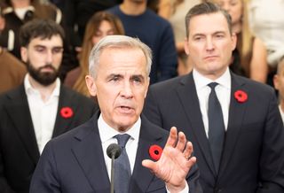 Prime Minister Mark Carney, centre, flanked by Aiden Gomez, left, co-founder and CEO of Cohere and Minister of Artificial Intelligence and Digital Innovation Evan Solomon, right, announces an investment of up to $1.6 billion in Canadian AI company Cohere, in Montreal on Thursday, Oct. 29, 2026.