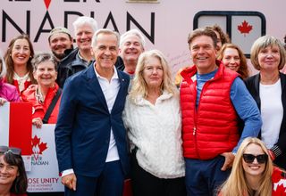 Prime Minister Mark Carney, centre left, volunteer Fran Milburn, centre, and Forever Canadian founder Thomas Lukaszuk, centre right, pose for a group photo with volunteers following a cabinet retreat in Banff, Alta., Friday, Sept. 11, 2026. THE CANADIAN PRESS/Jeff McIntosh