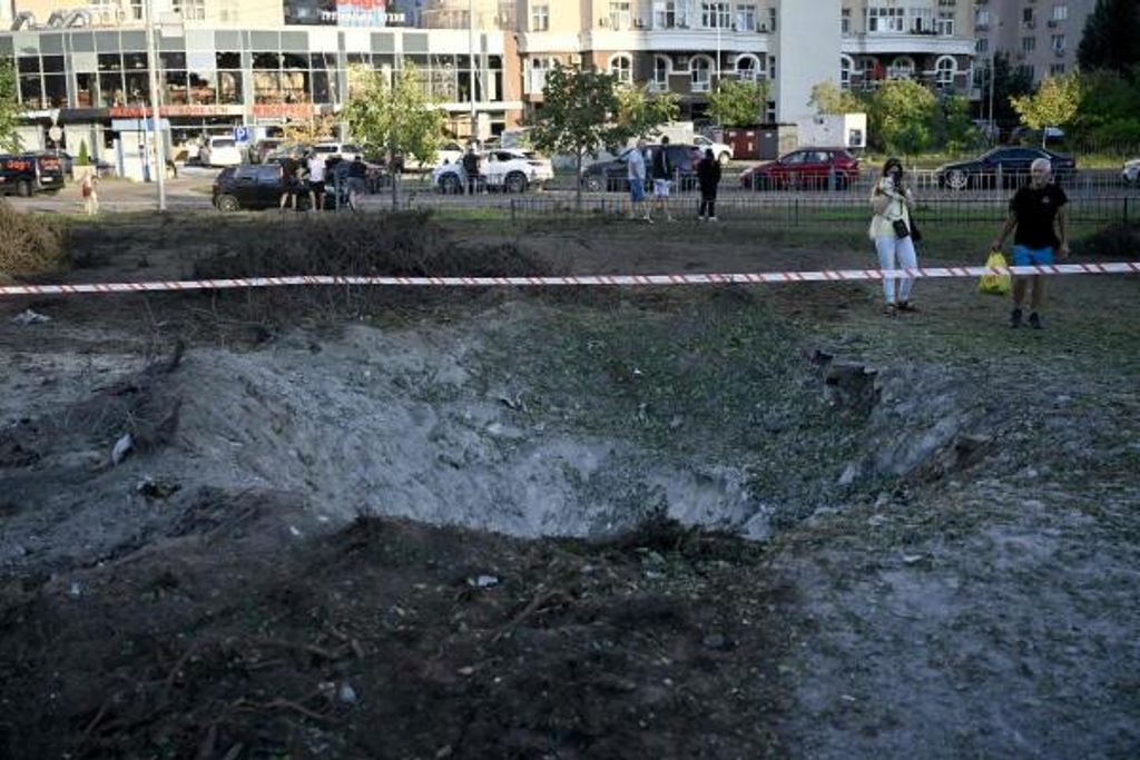 Menschen untersuchen einen Krater, der durch eine russische ballistische Rakete in der Nähe einer Kinderklinik entstanden ist, nachdem es am 1. August 2026 zu massiven russischen Raketenangriffen auf die ukrainische Hauptstadt Kyjiw gekommen war.
