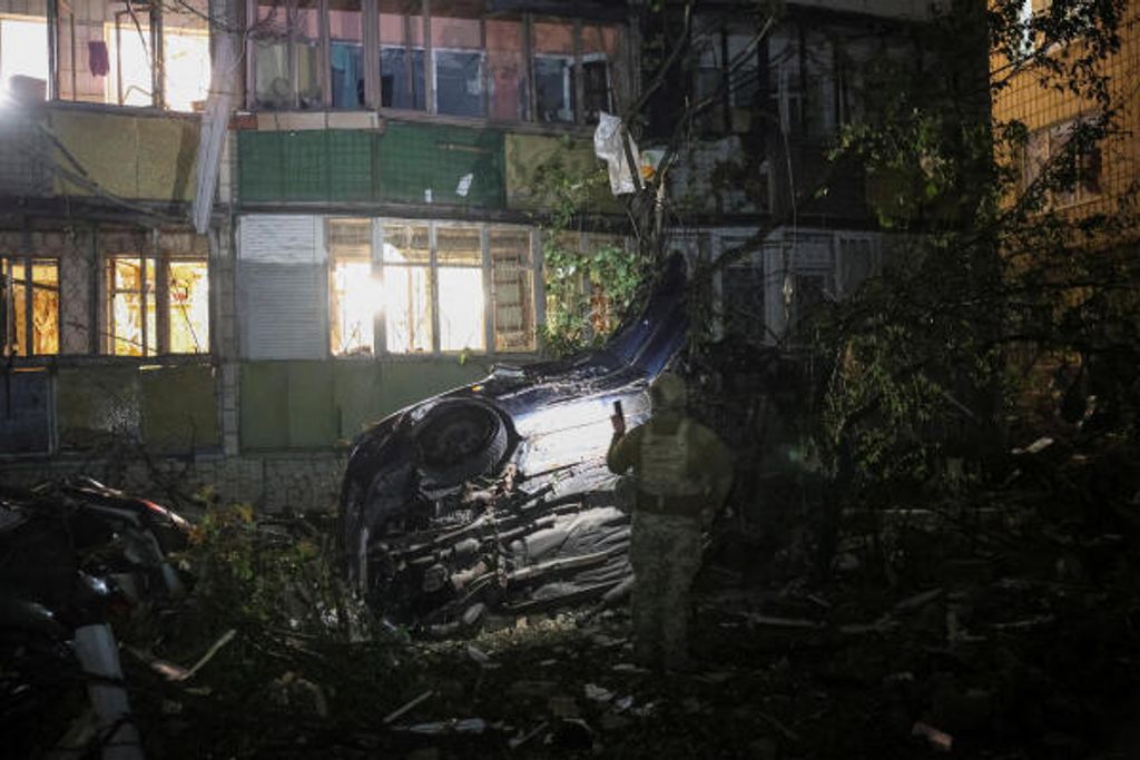 Ein Polizeibeamter begutachtet am 20. August 2026 in Kyjiw den Ort eines Raketenangriffs auf ein Wohnhaus.