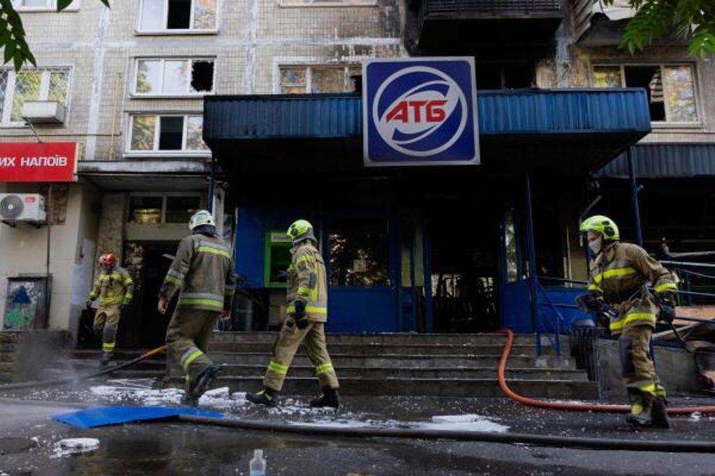 Feuerwehrleute sind am 26. September 2026 in Kyjiw nach einem Drohnenangriff in der Nähe eines beschädigten Supermarkts im Einsatz.
