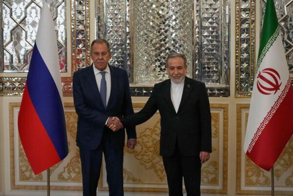 Der iranische Außenminister Abbas Araghtschi gibt dem russischen Außenminister Sergej Lawrow vor ihrem Treffen die Hand.